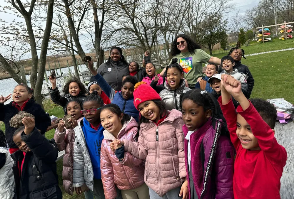 Students celebrate together during an outdoor waterfront program