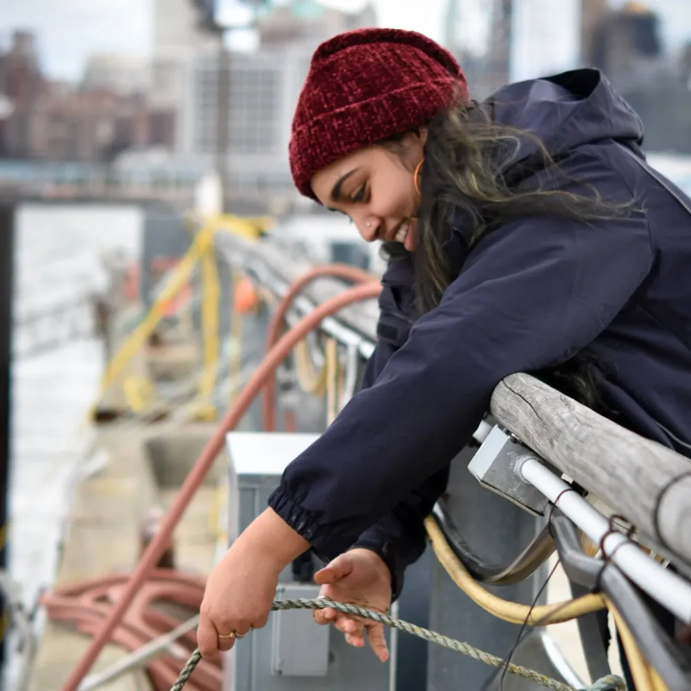 Crew member works with ropes aboard a restoration boat