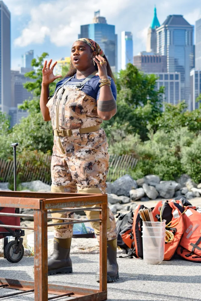 Performer stands on a chair during an outdoor Governors Island event