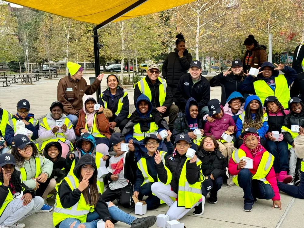 Students and educators pose together in high-visibility vests