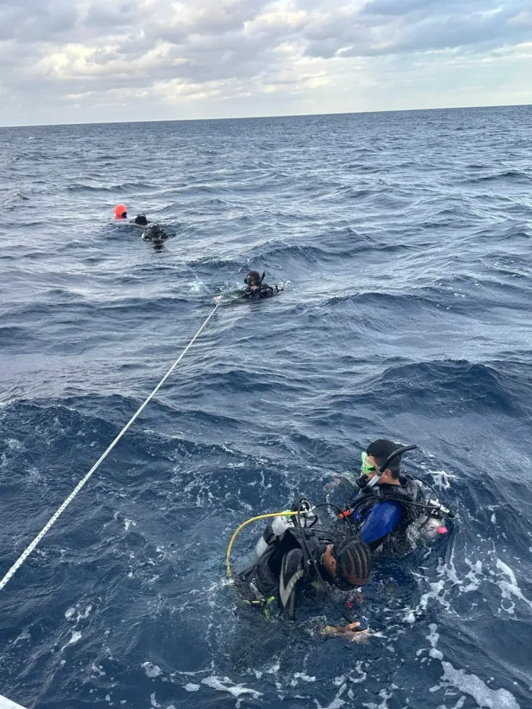 Divers float at the surface beside their boat