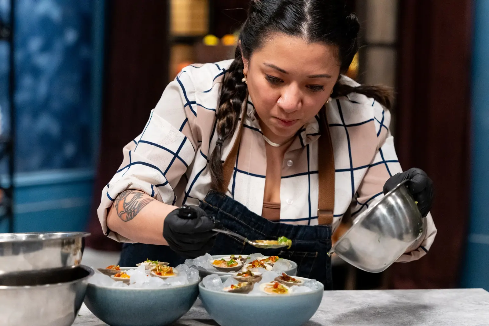 Chef Ayaka Guido prepares a plated dish in a restaurant kitchen