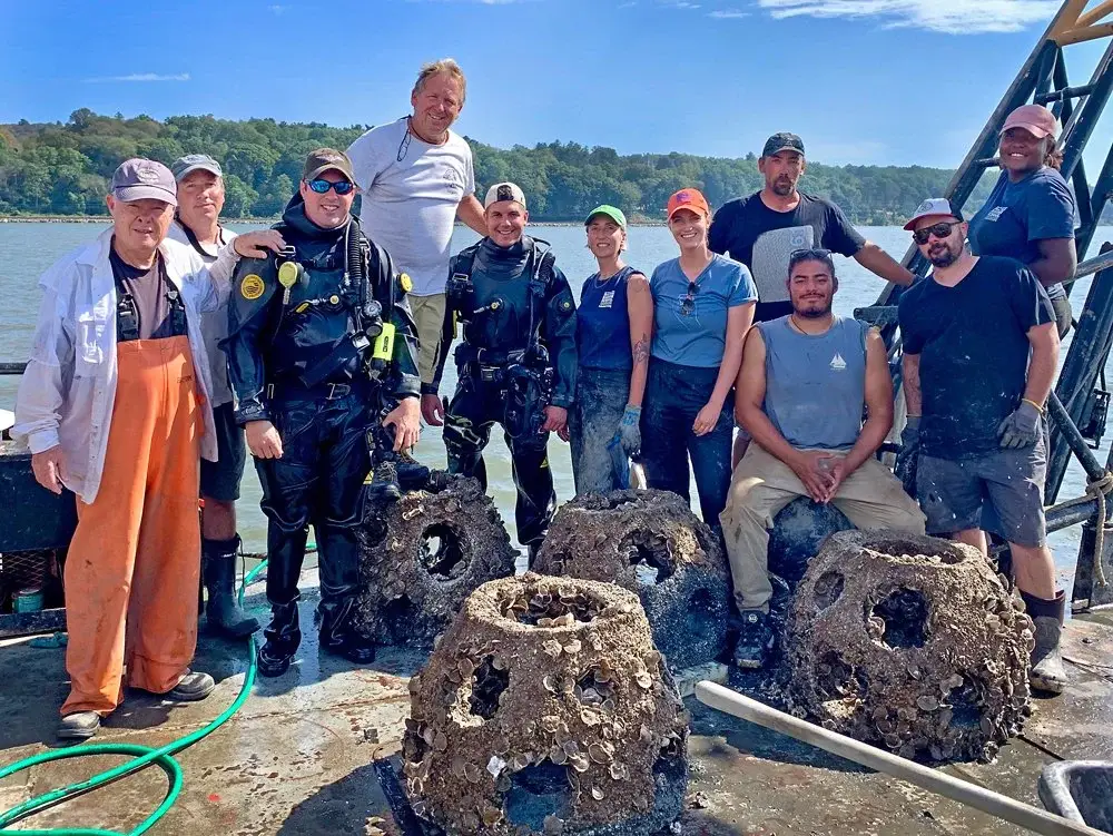 Participants pose behind reef structures on a boat