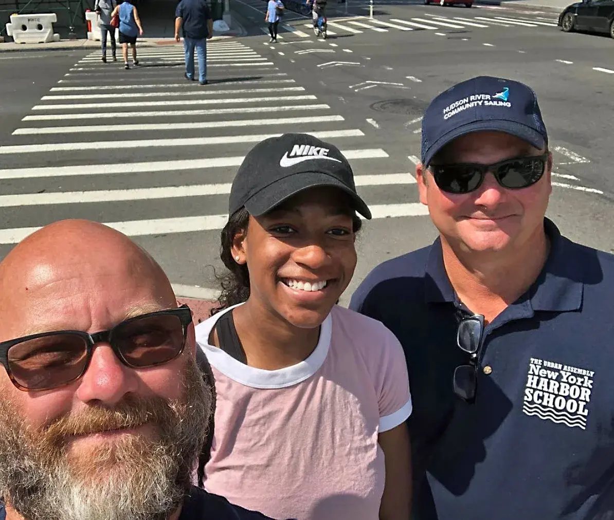 Harbor School alumna Awa Sylla poses with two colleagues on a city street