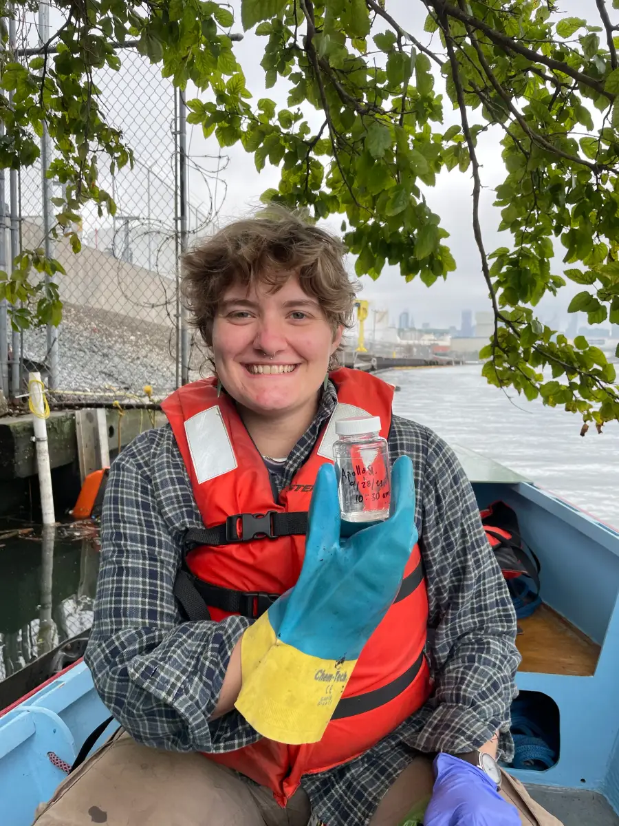 A team member wearing a life jacket sits aboard a boat