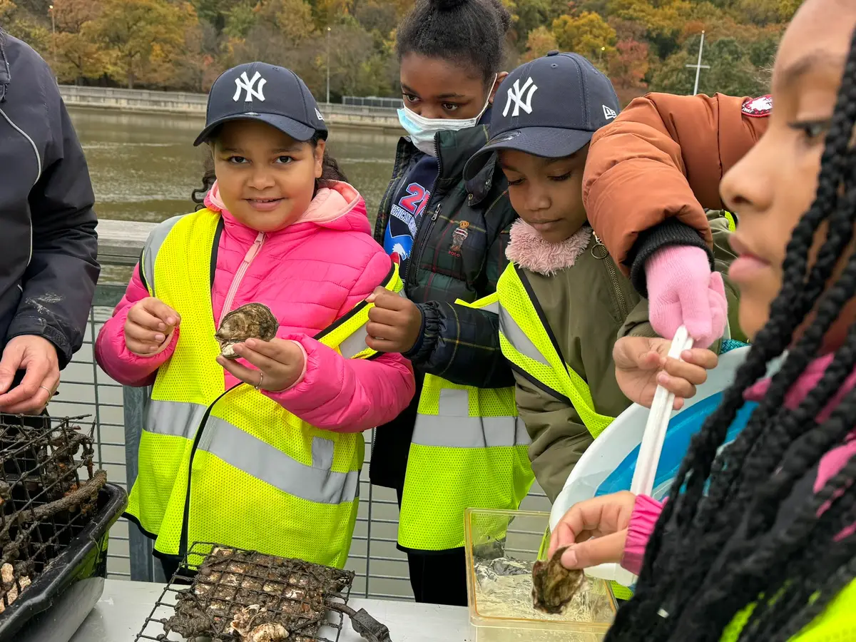 Children examine oysters together during an outdoor classroom activity