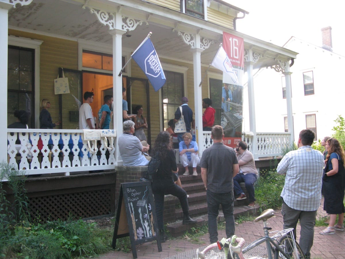 Guests gather outside a historic building for an oyster social