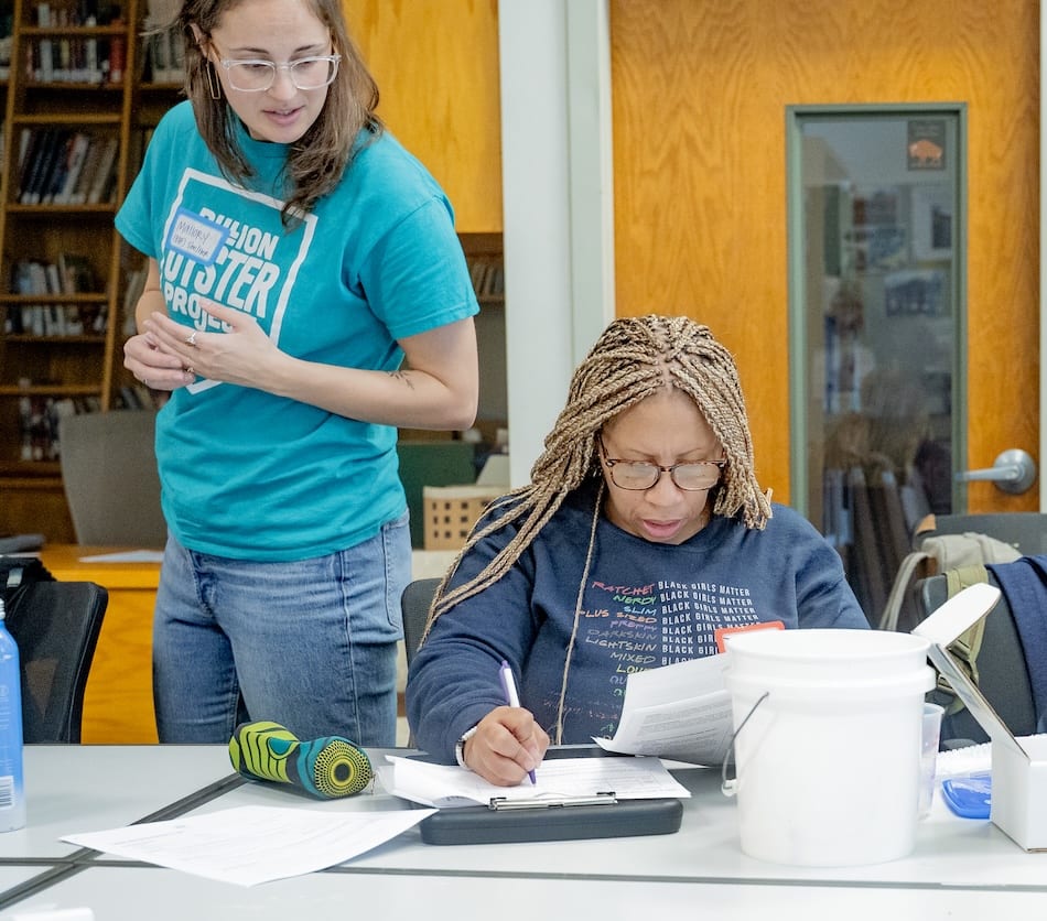 A Billion Oyster Project staffer coaches a teacher completing a data sheet at an educator training