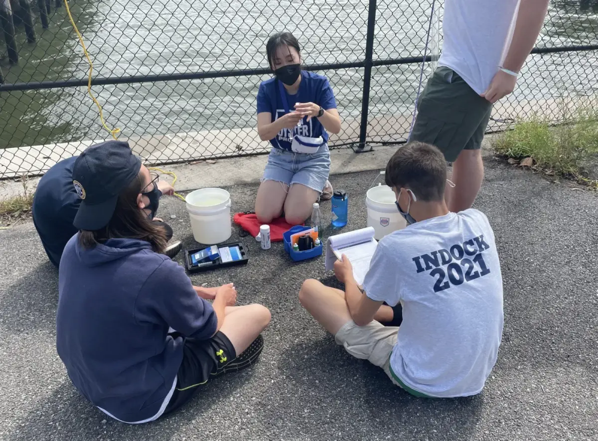 Students conduct water-quality tests together outdoors