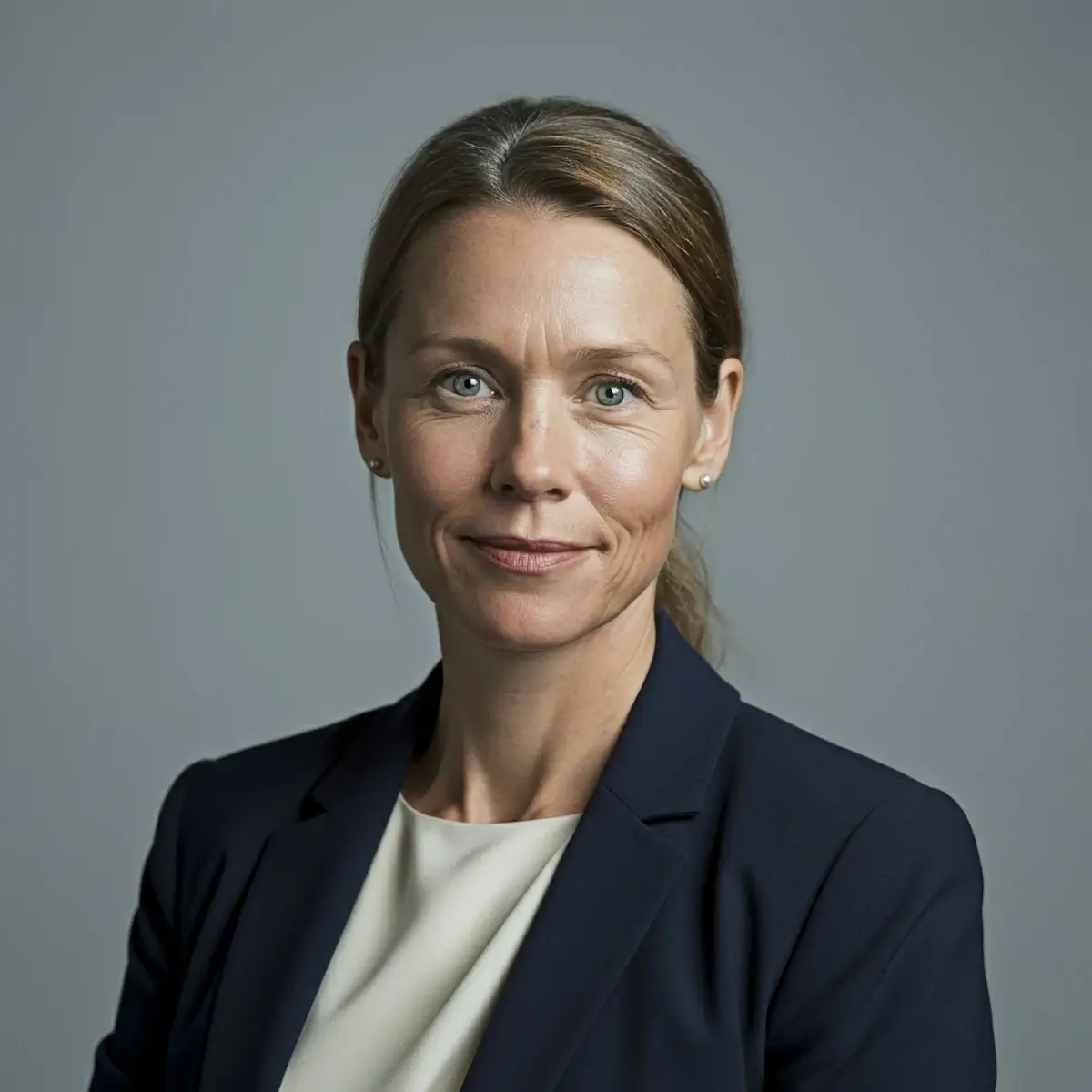 Portrait of a woman with blonde hair wearing professional attire against a neutral background