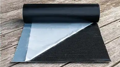 Eine selbstklebende EPDM-Rolle, etwas ausgerollt, mit teilweise gelöster Schutzfolie.Garten Eben