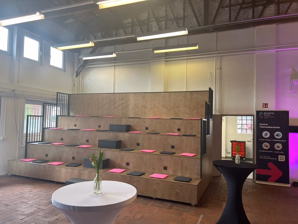 Flexible Sitztribüne aus Holz mit Sitzkissen im Eventbereich der SmartCityWerkstatt