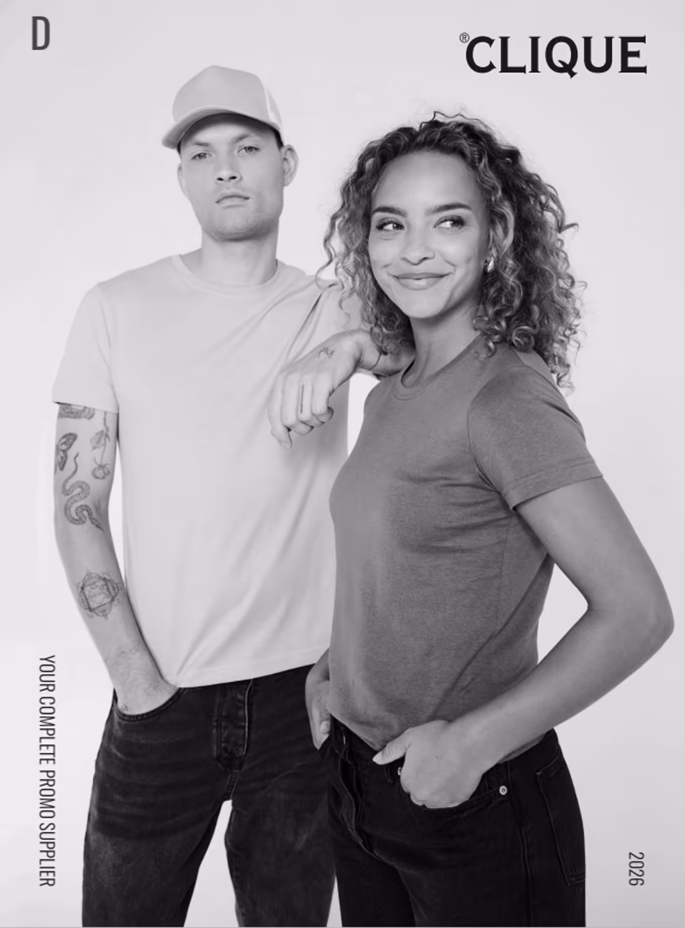Ein Mann mit Basecap und Tattoo-Ärmel neben einer lächelnden Frau mit lockigem Haar, beide in T-Shirts.
