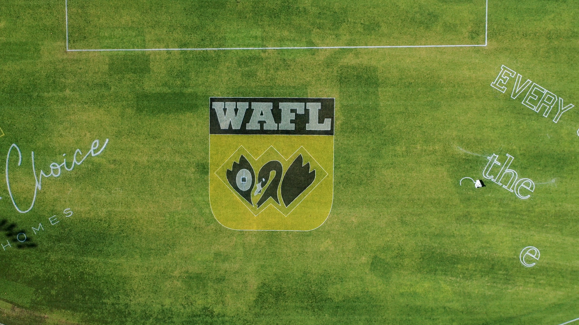Aerial view of WAFL crest painted on a grass oval with surrounding sponsor linework