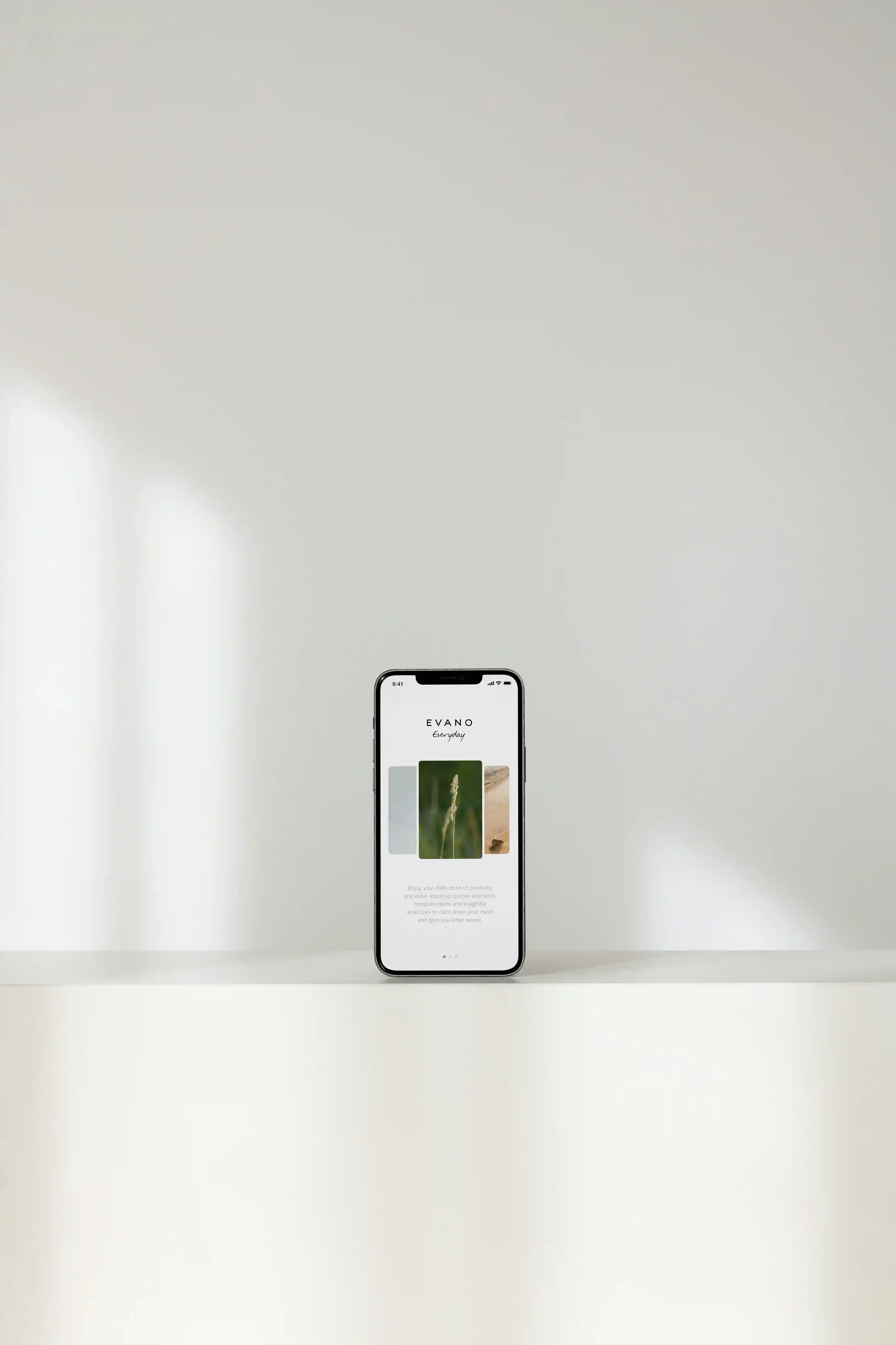 Smartphone displaying the Evano Everyday app screen with images of nature on a white surface against a plain light background.