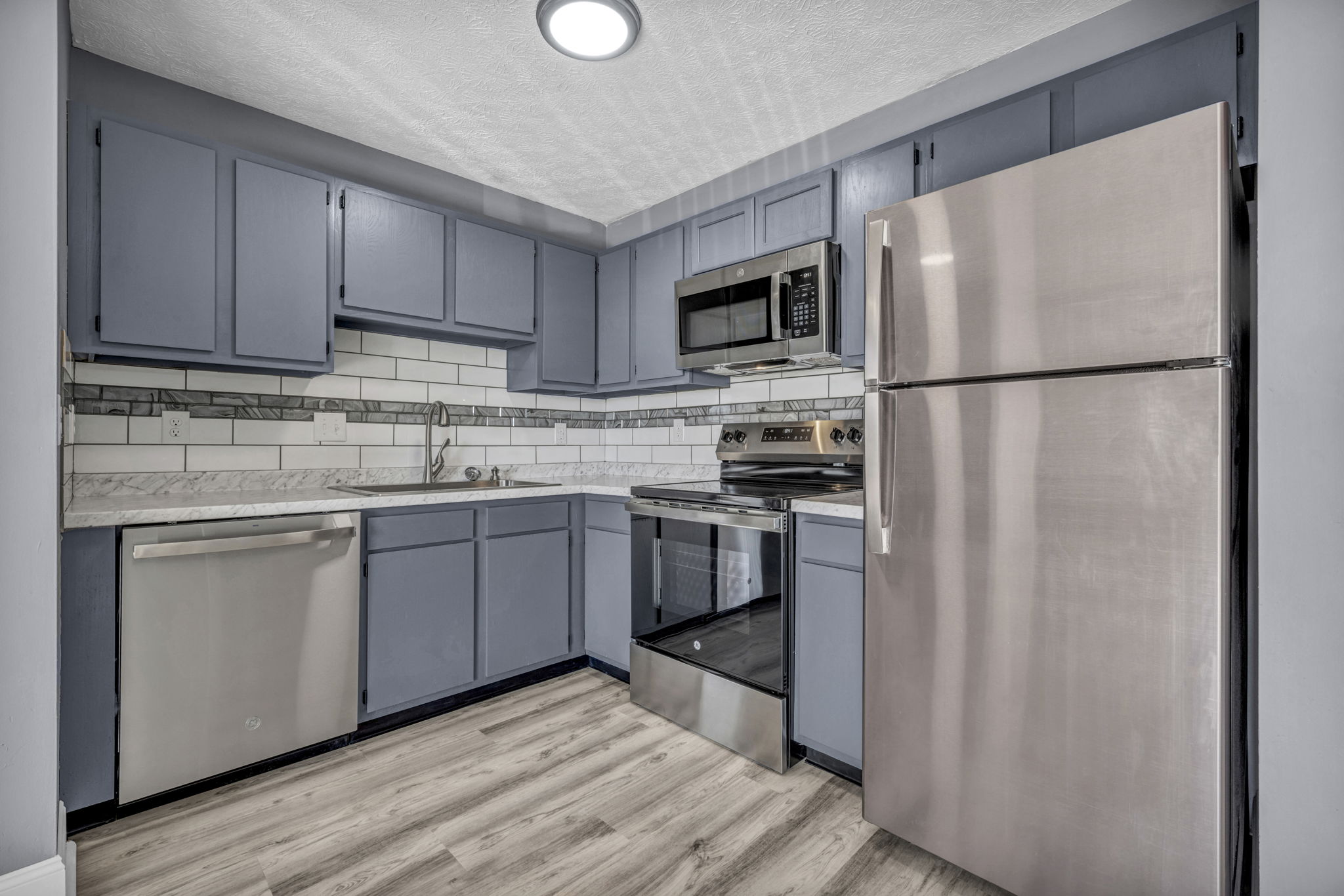 kitchen closeup of dark grey cabinets and stainless appliances