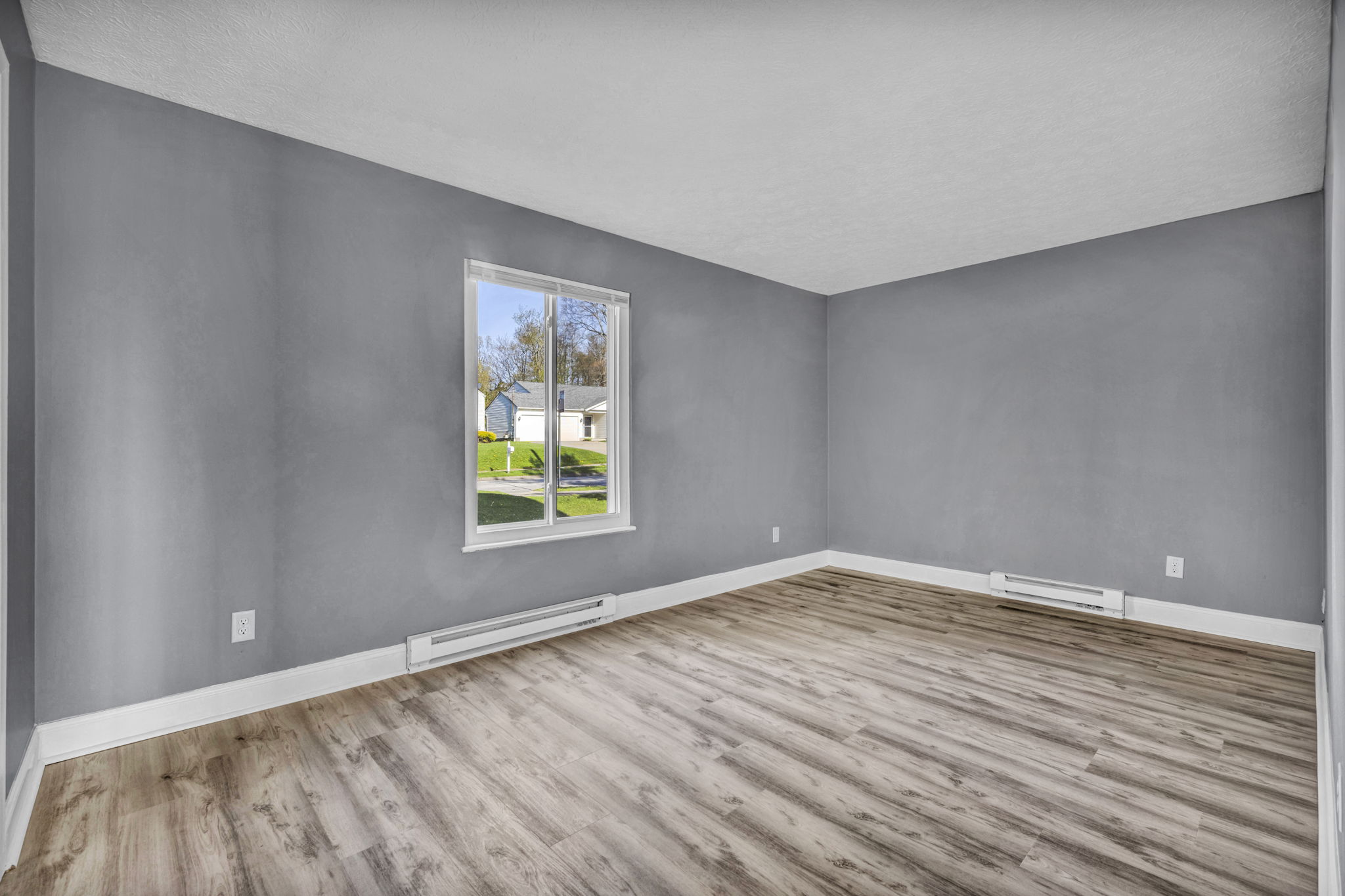 bedroom photo with window, hardwood floor, white trim and grey walls