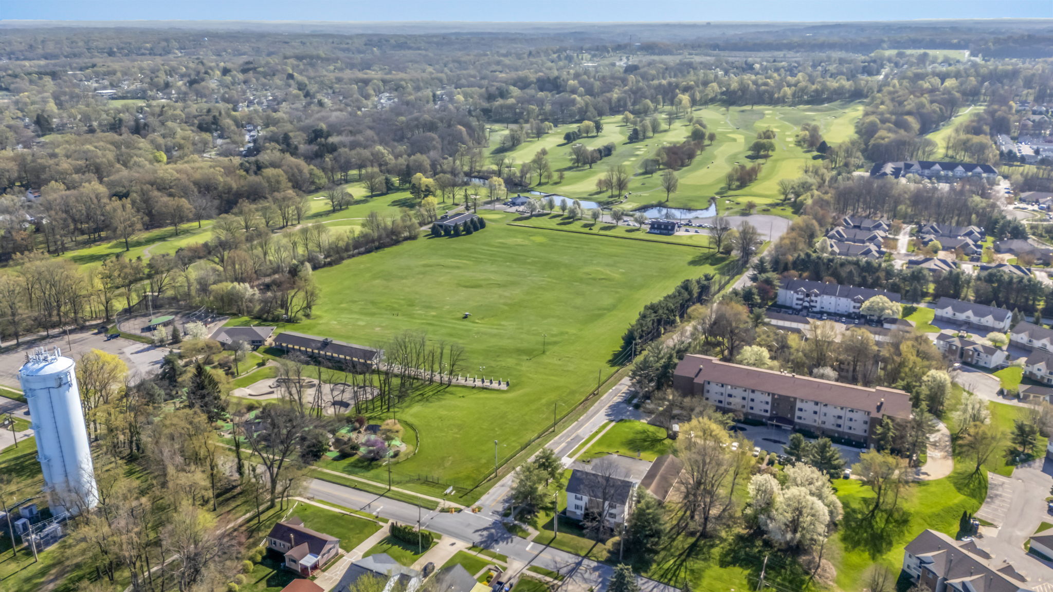 high aerial photo from drone of brookledge golf course and driving range with communities surrounding it
