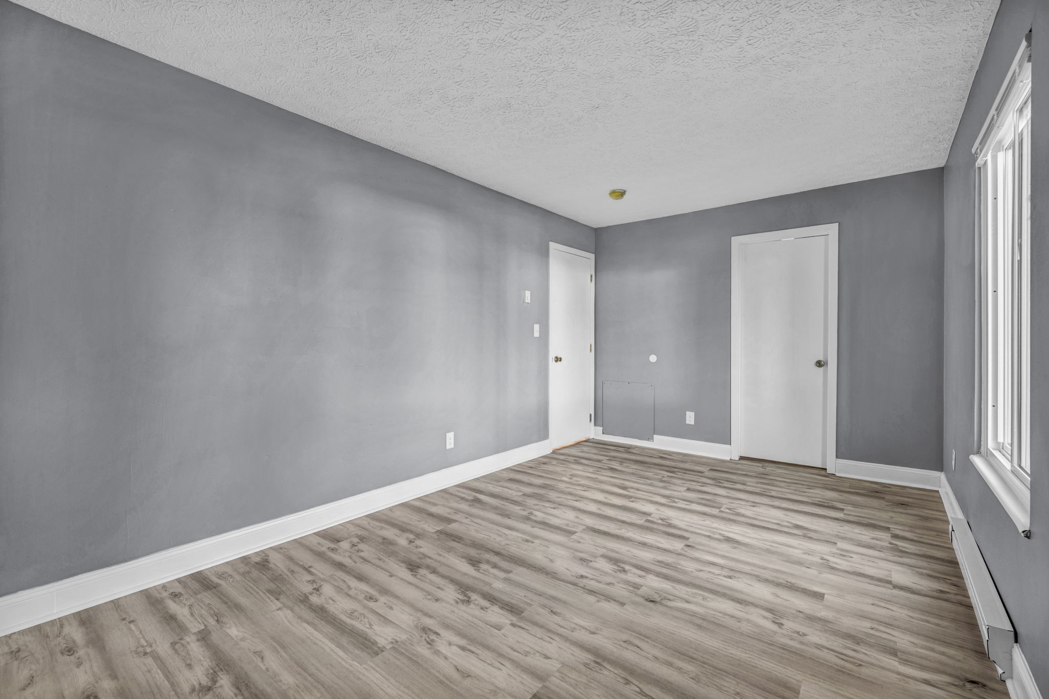 bedroom photo white door and closet, hardwood floor, white trim and grey walls