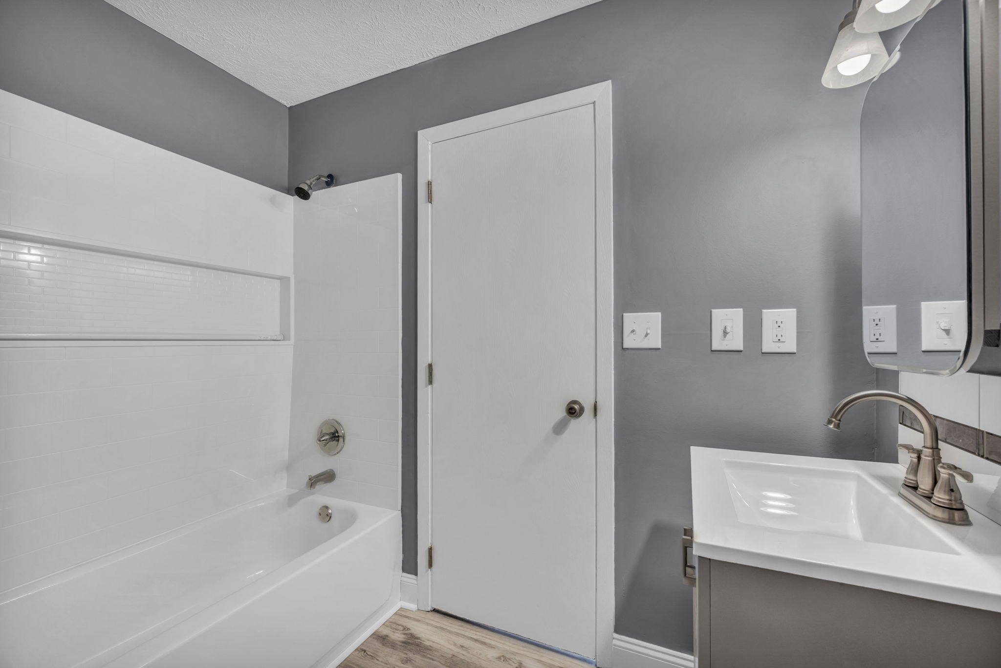 bathroom photo looking at exit door shower and sink