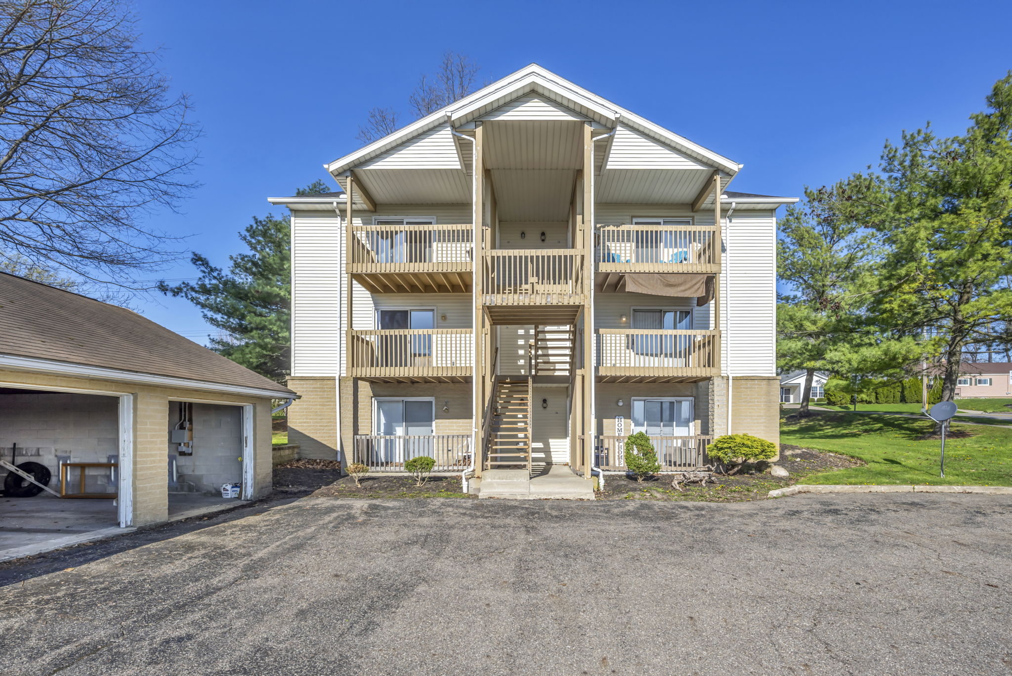 apartment building with 6 balconies, and garage to the left of it