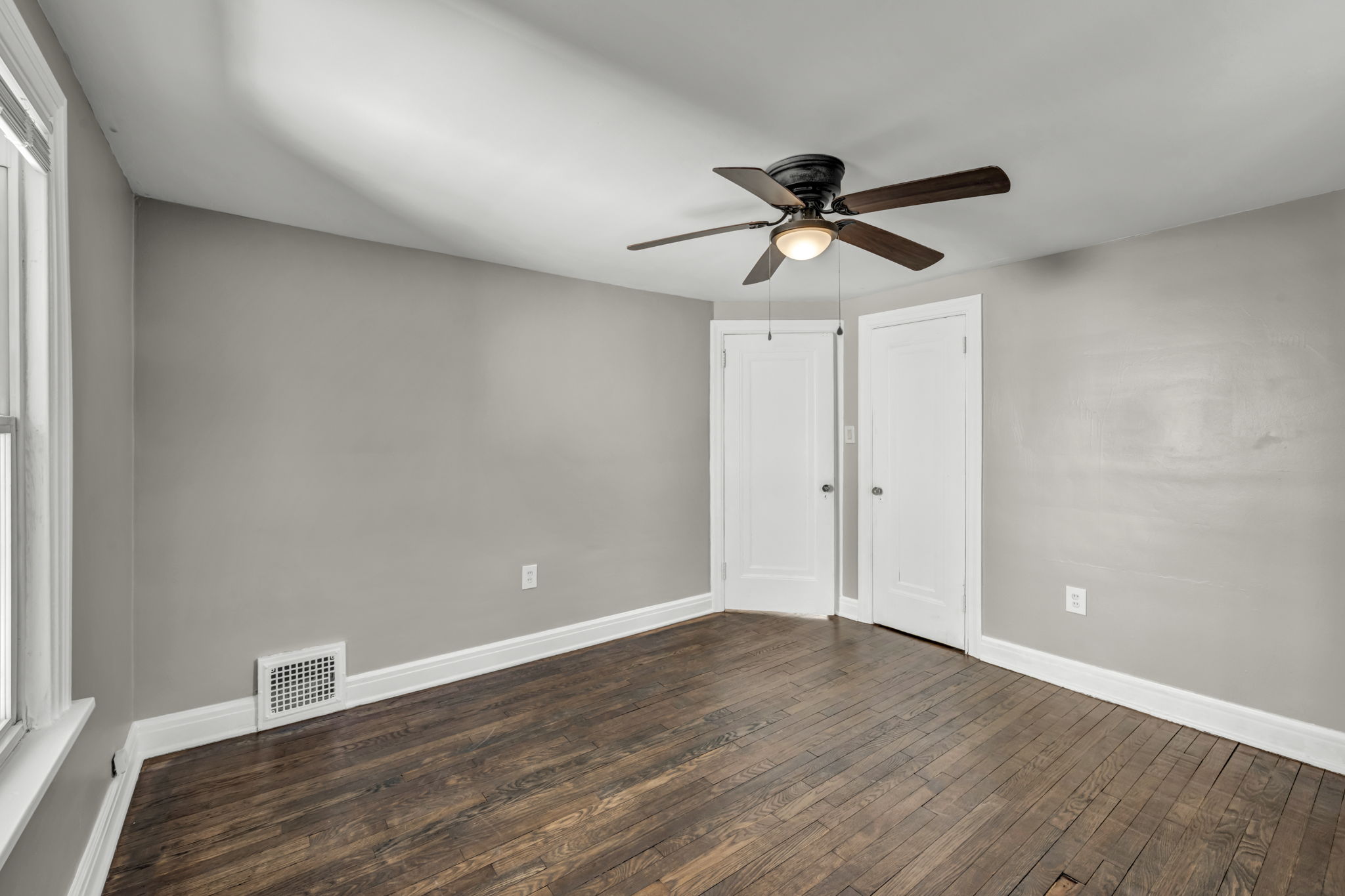 bedroom two with two white doors and brown hardwood floors