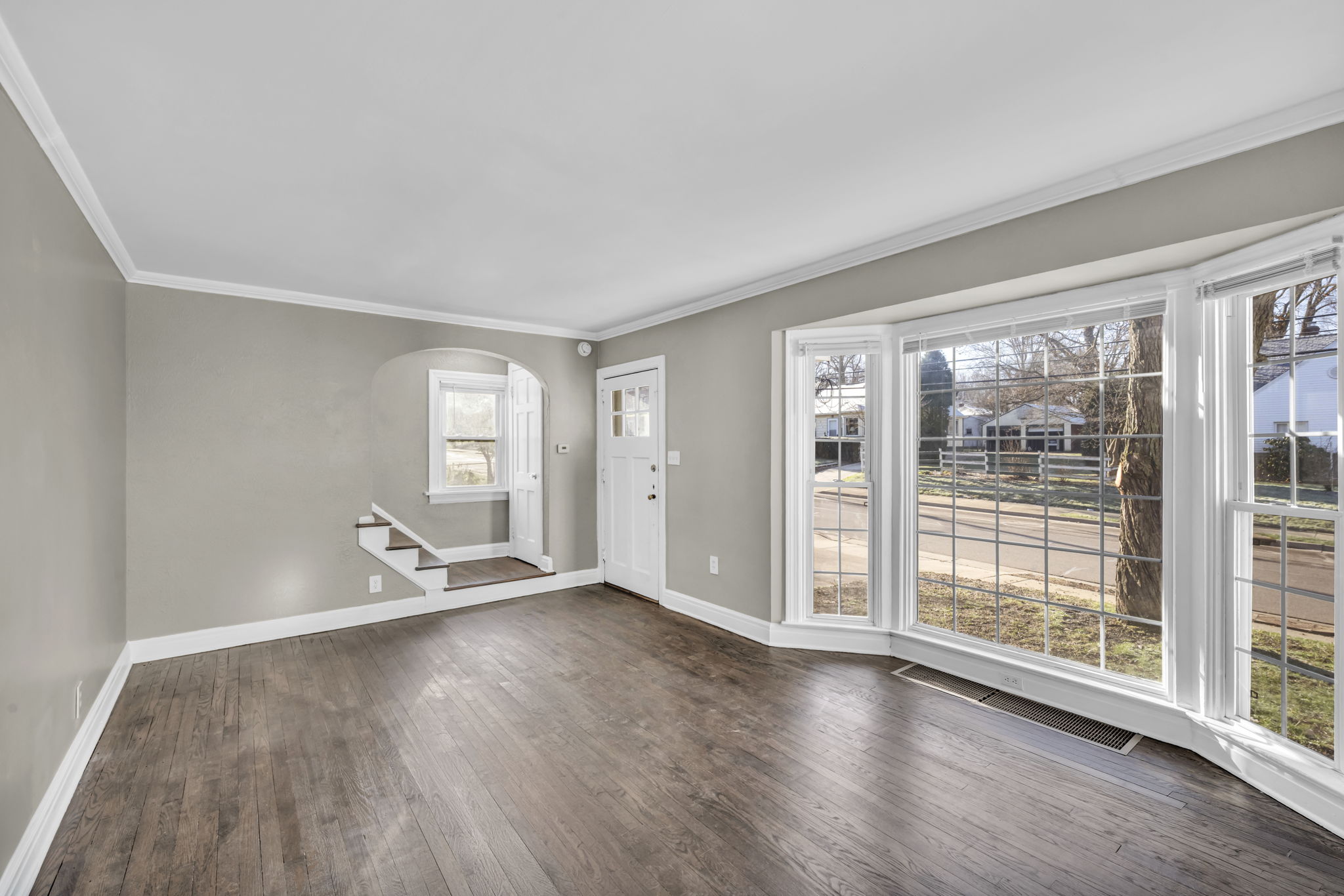 living room with brown vinyl plank floor and large window