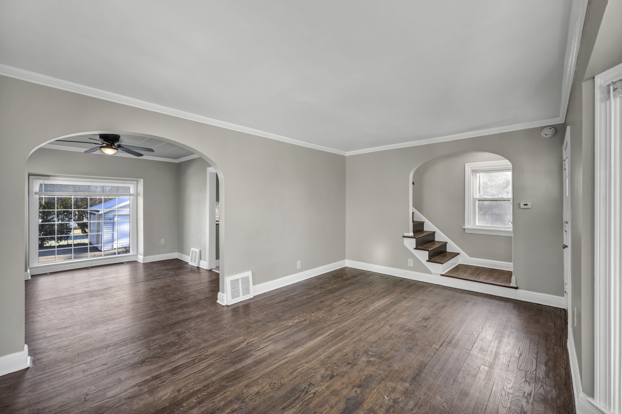dinning room with beige walls brown plank floor and upstairs entrance