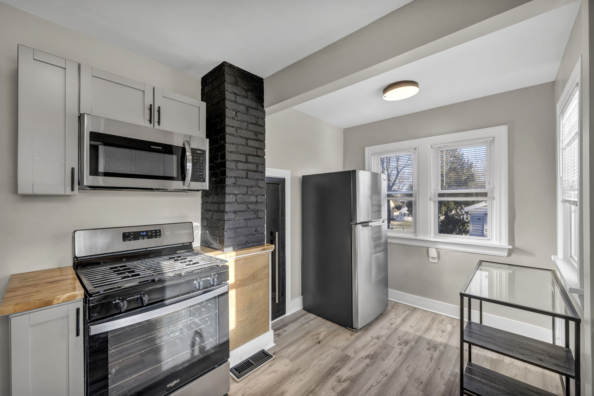 kitchen with butcher block counter tops and black painted brick column