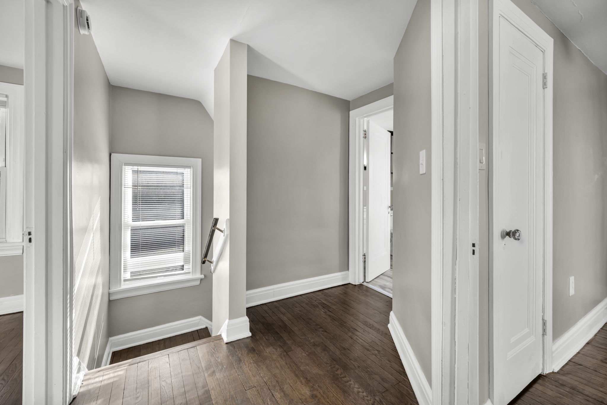 picture of hallway with doors open into rooms upstairs with view of going down stairs