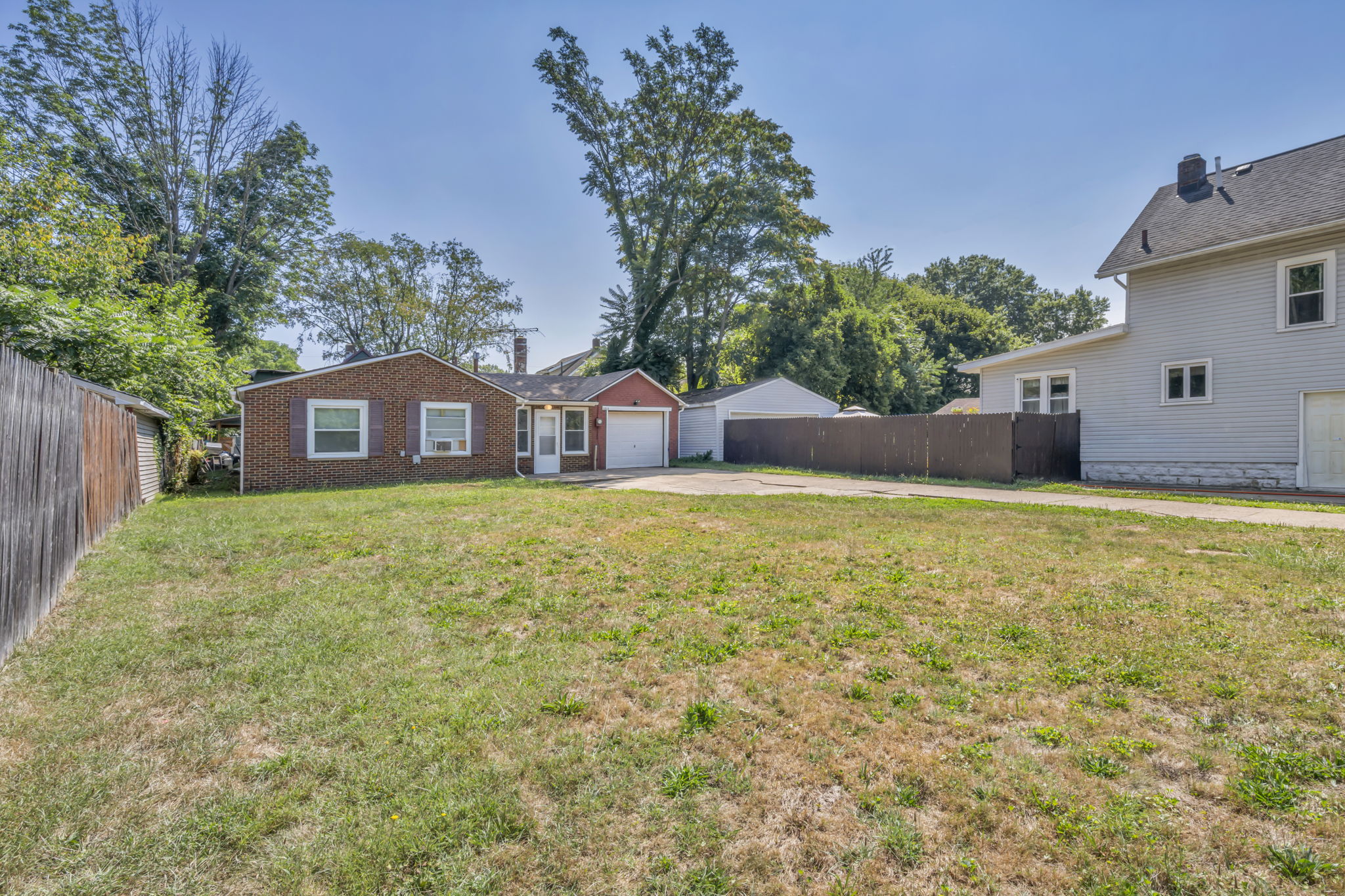 full yard and driveway photo with home far back 2