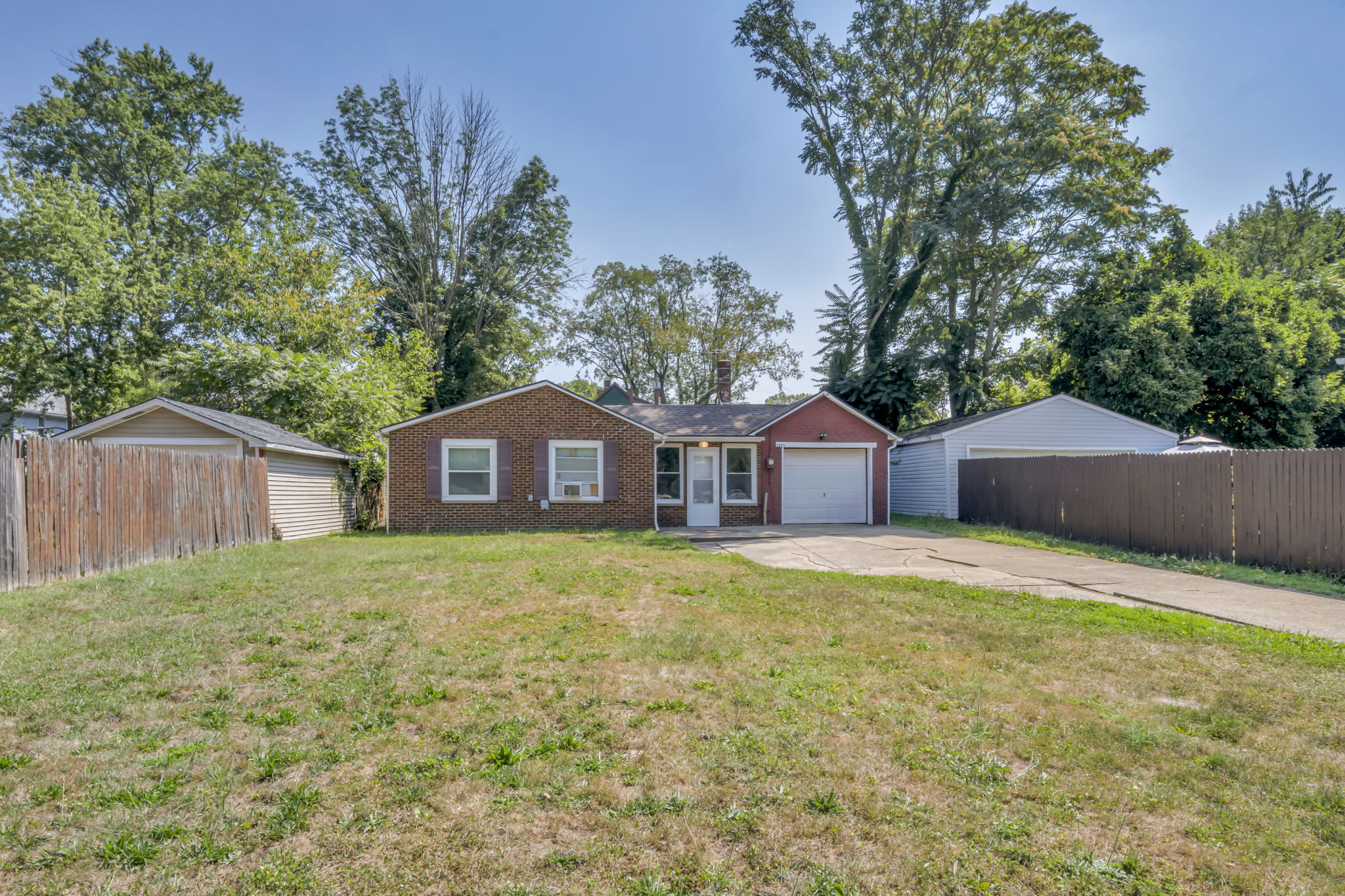 full yard and driveway photo with home far back