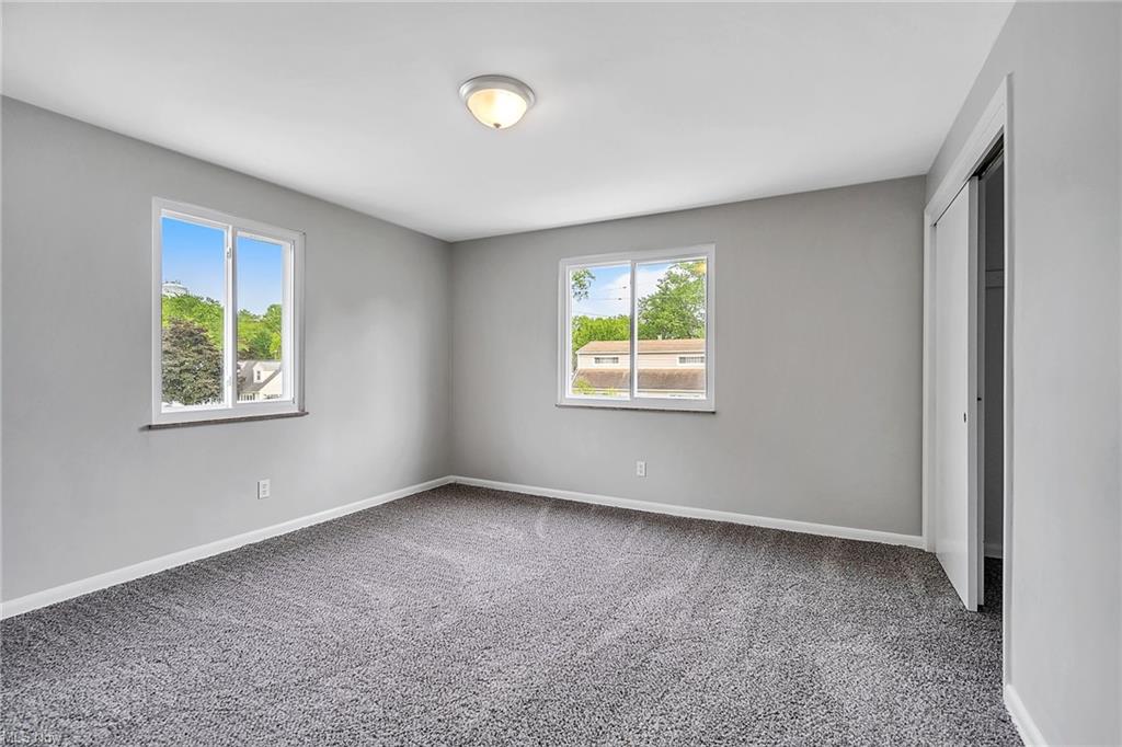 carpeted bedroom two windows