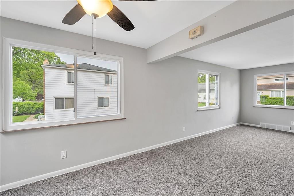 living room with carpet and three windows