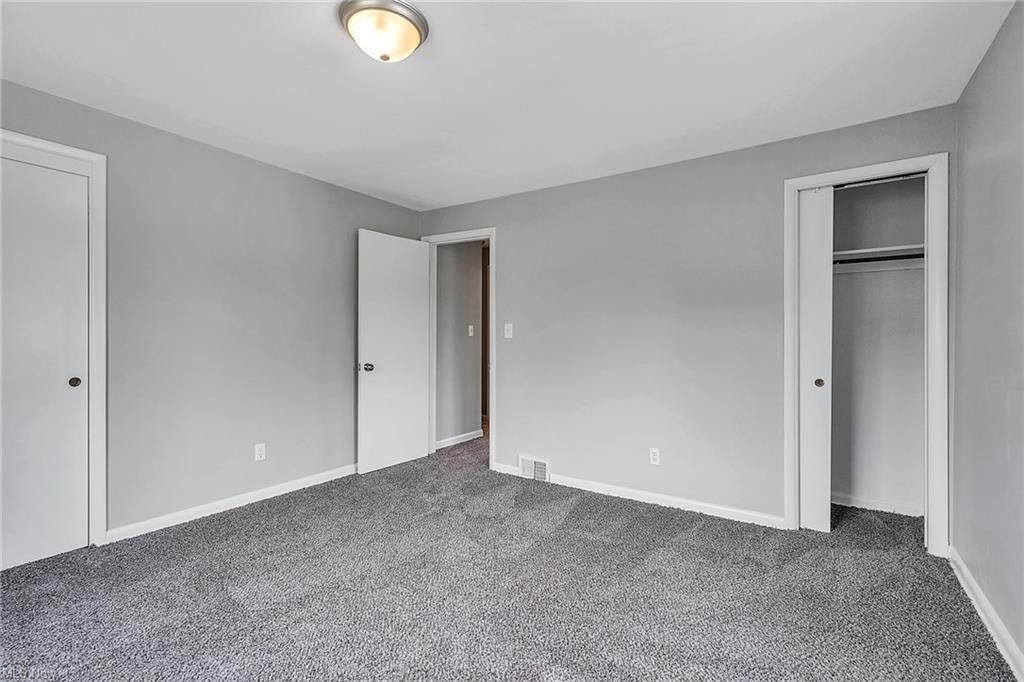 carpeted bedroom photo with two closet doors