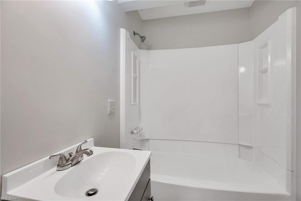 bathroom with shower and tub and vanity with sink