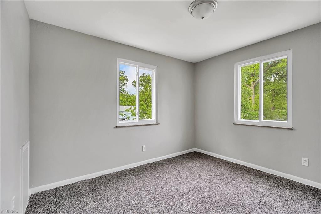 carpeted bedroom with windows on each wall