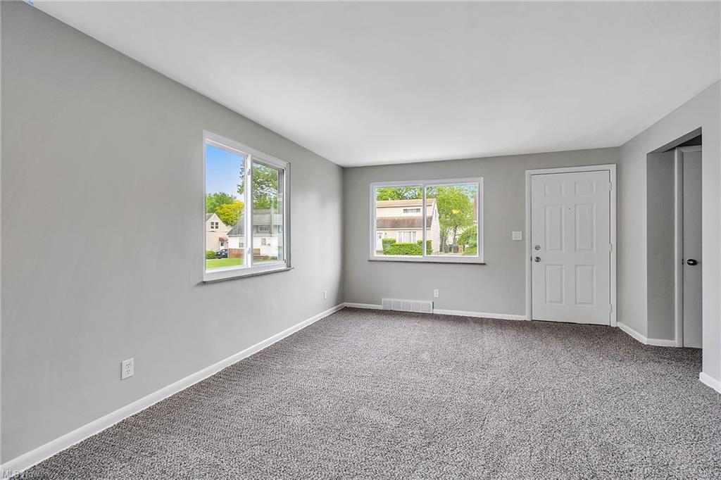 carpeted room with two windows