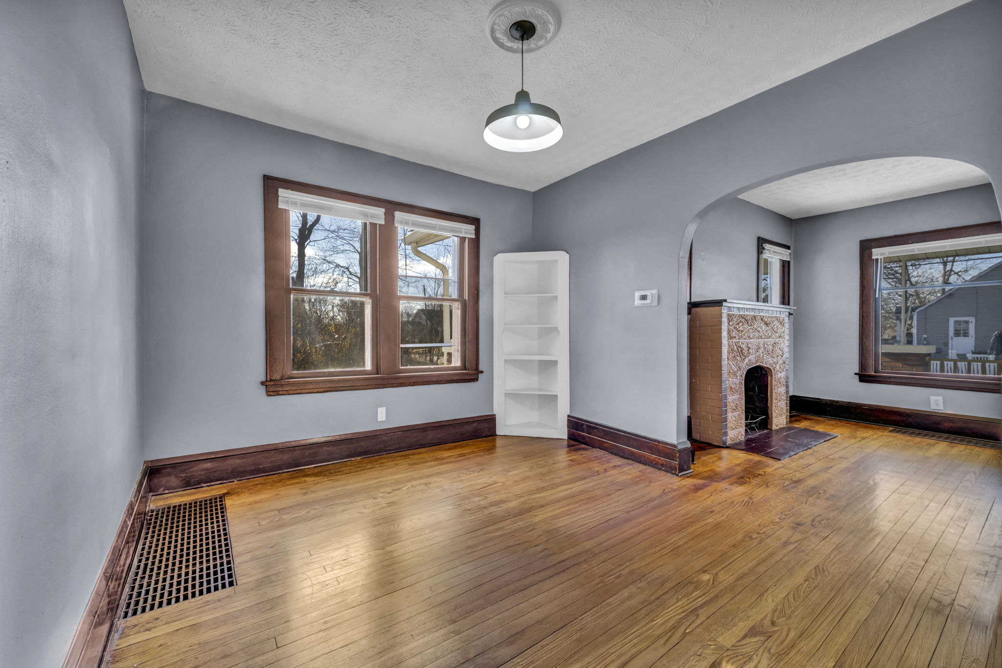 hardwood floor of living room with fireplace and wood trim