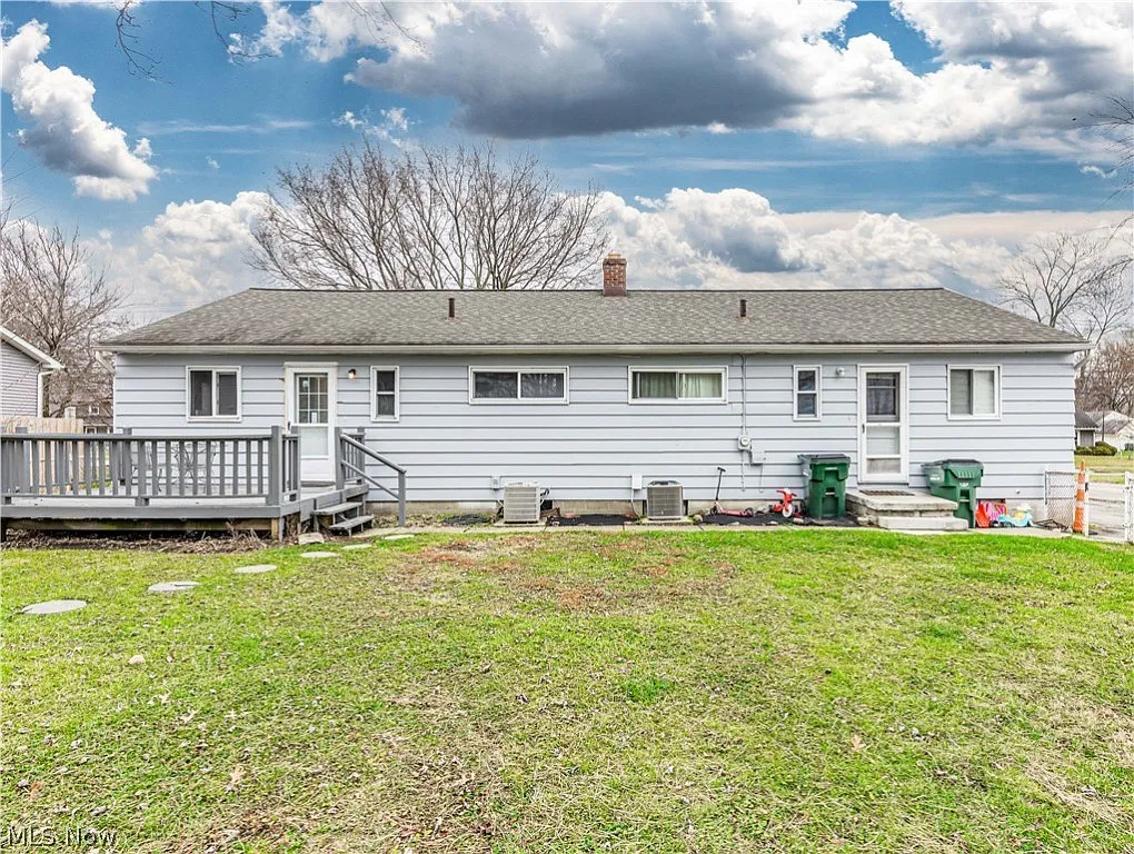 duplex backyard photo at both units showing one unit with a porch and the other with small stairs and yard shared between them