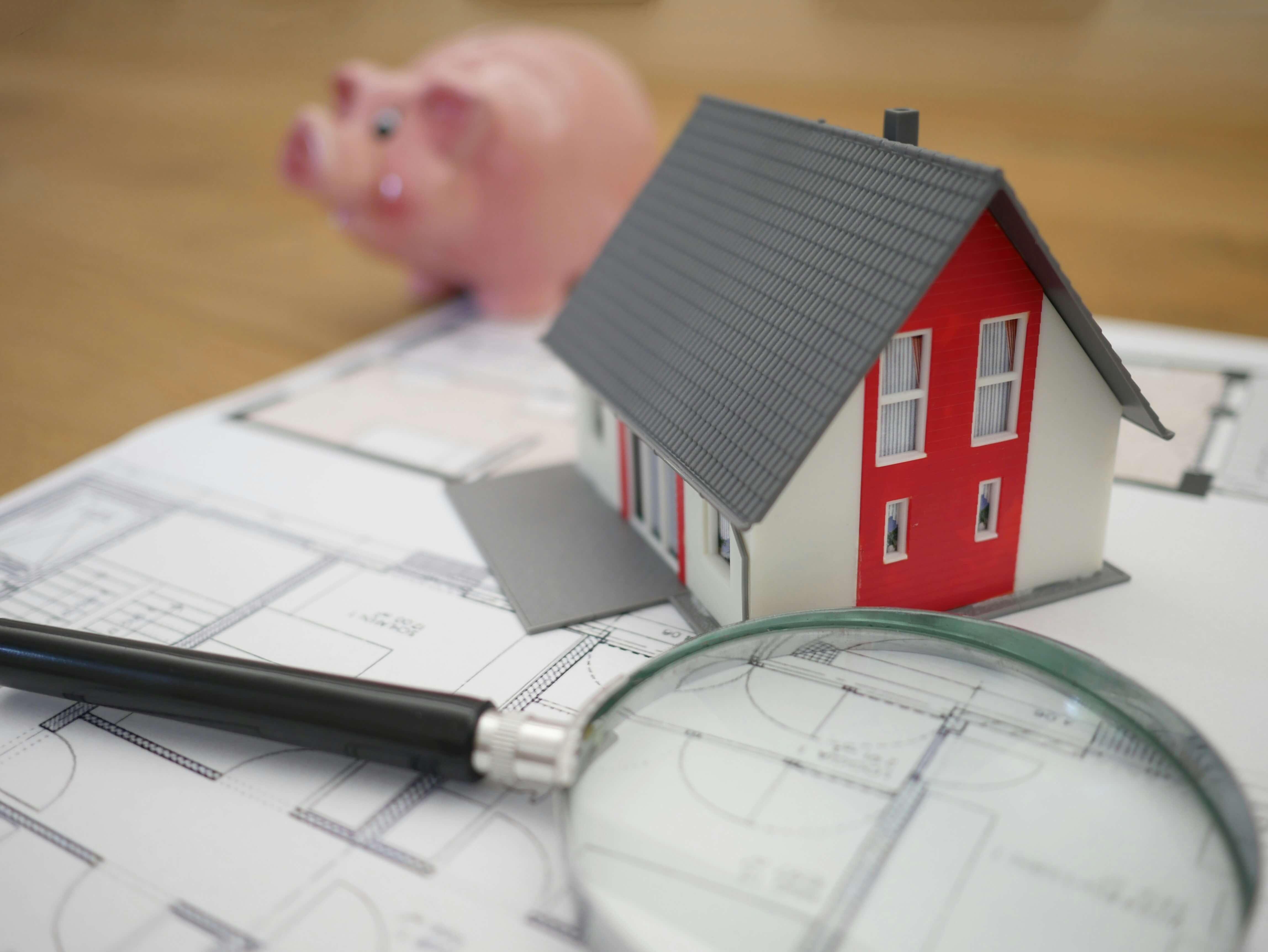 Picture of a small desktop sized home and a magnifying glass
