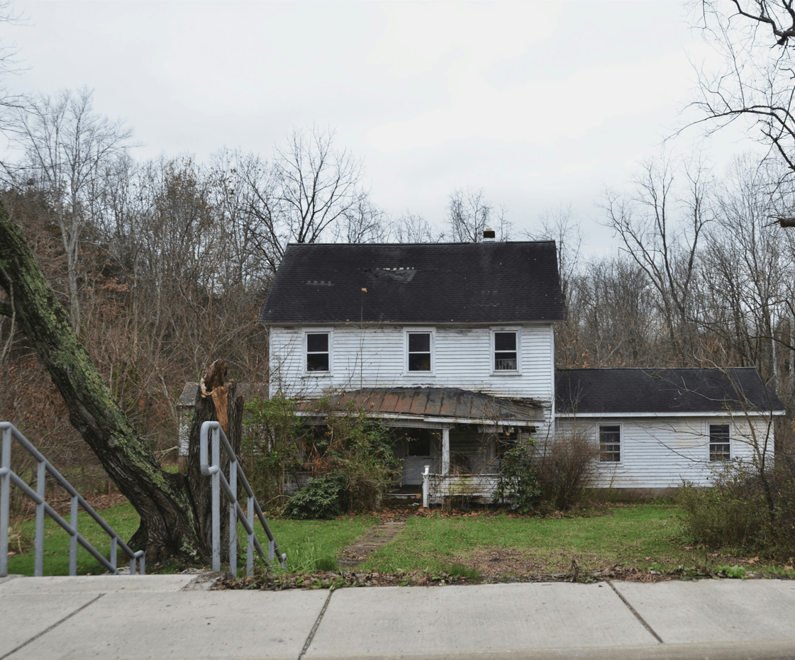 condemned old tough looking home with grey sky