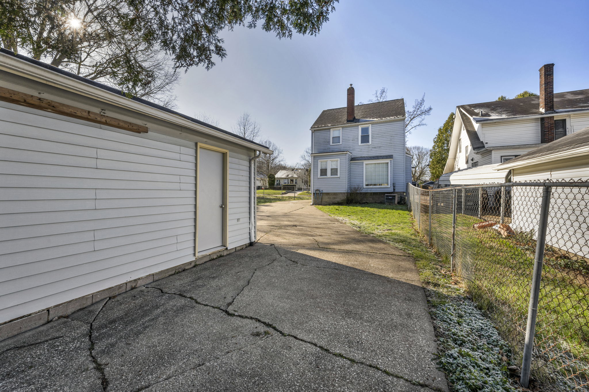 photo from garage with house in front vinyl siding and concrete