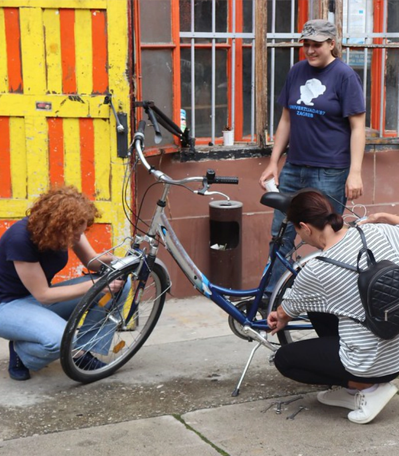 three people repairing a bicycle