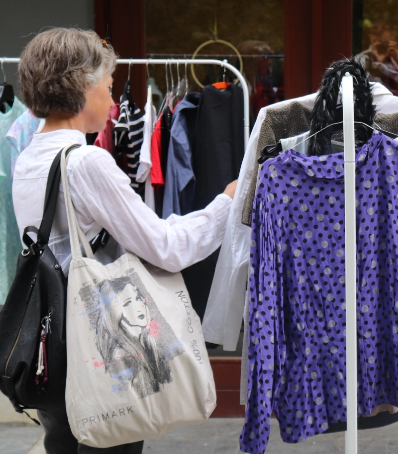 a woman browsing through second-hand clothing