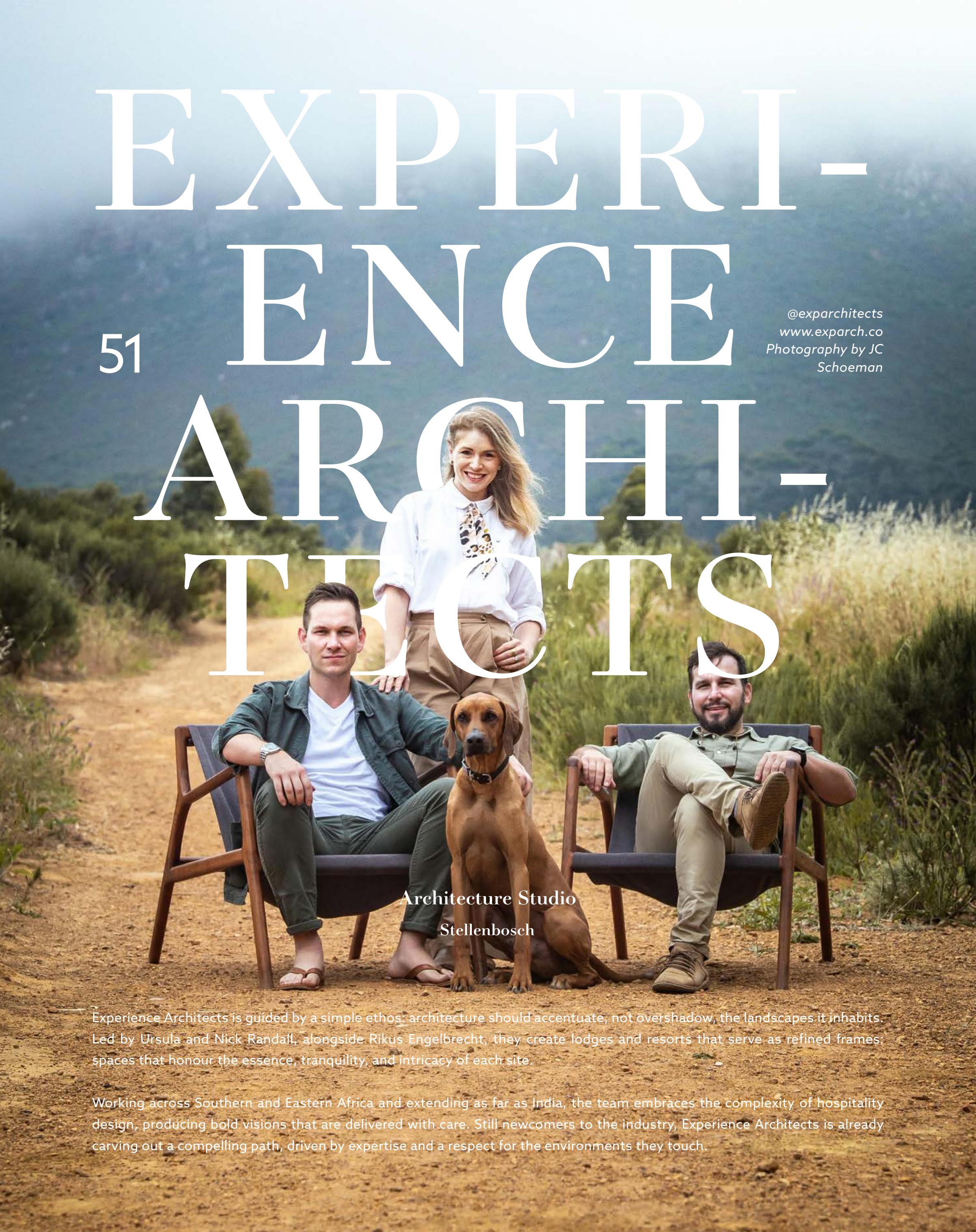 Three architects smiling outdoors on a dirt path with a dog, two seated and one standing behind.