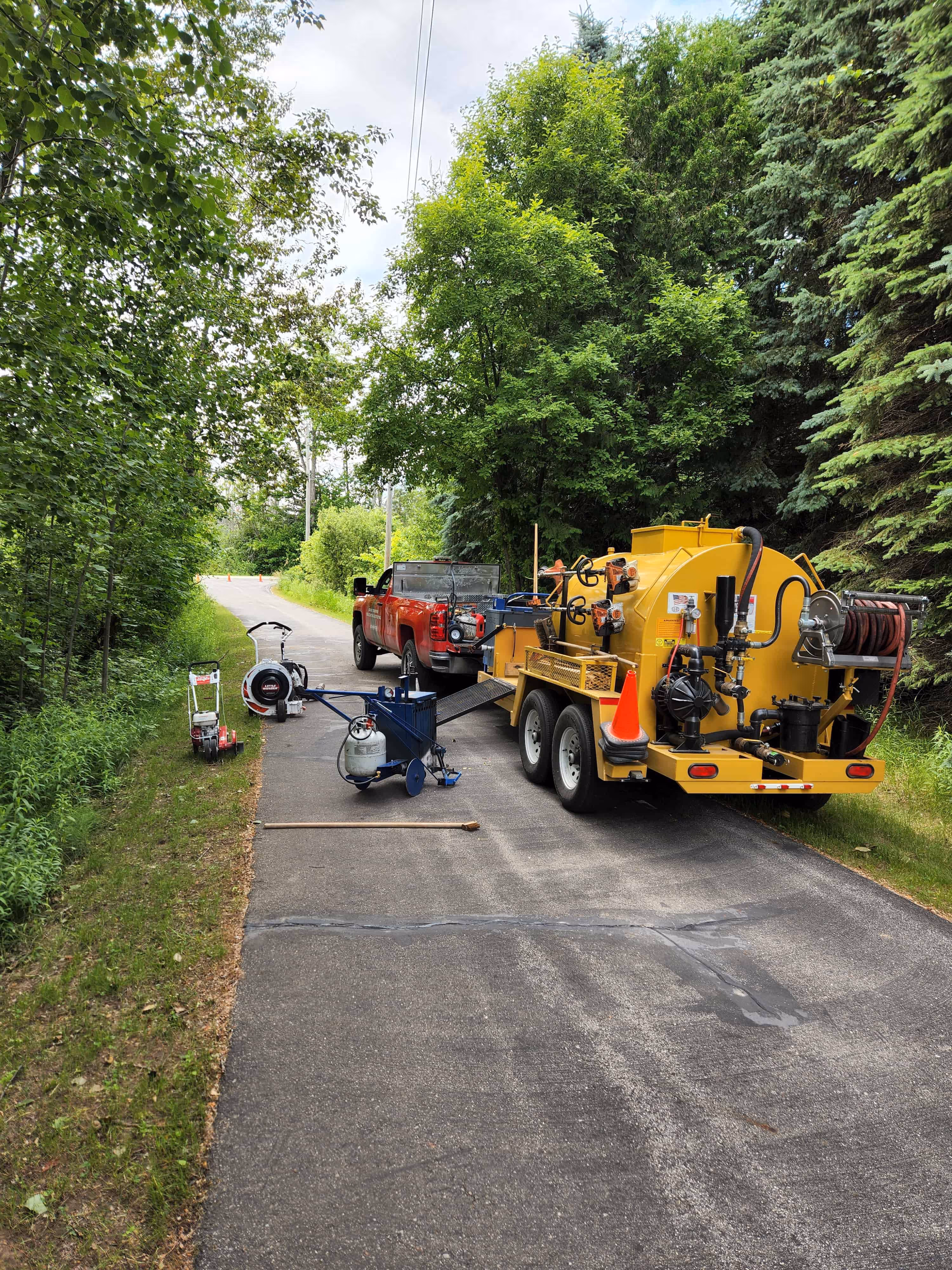 Grand Traverse Sealcoating & Striping professional equipment arriving for residential driveway sealcoating on Old Mission Peninsula in Traverse City, MI, utilizing the 6-Step Asphalt Armor System for maximum pavement protection.