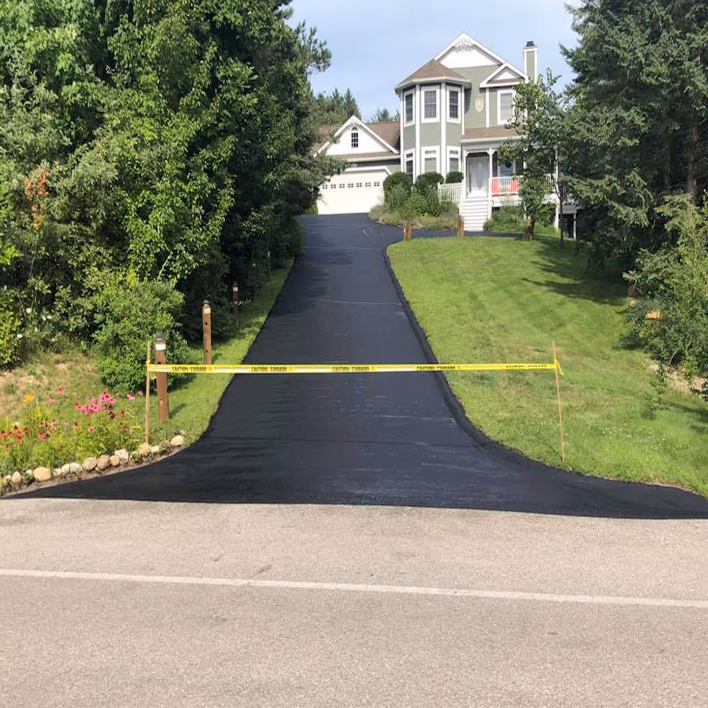 Comprehensive crack filling and sealcoating for a residential driveway near Lake Leelanau.