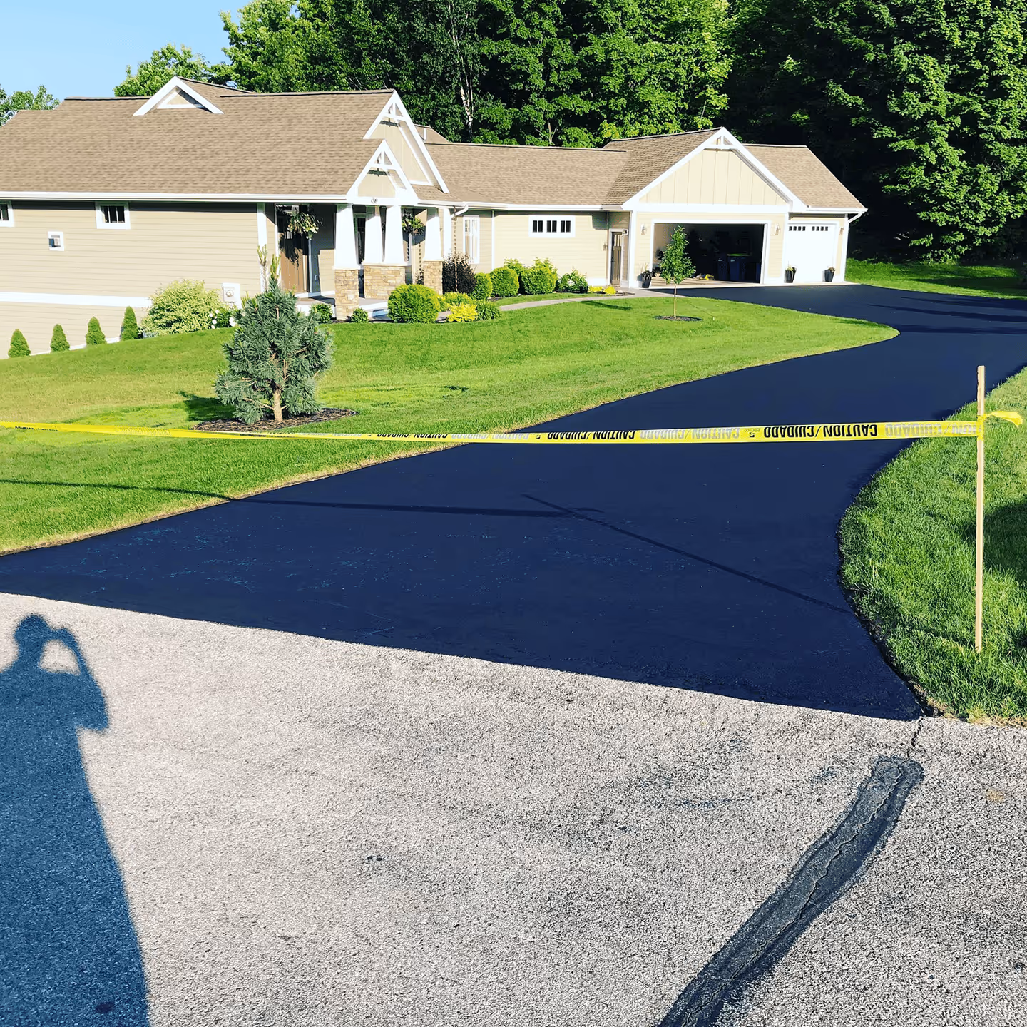 Professional residential driveway sealcoating for a home in a Traverse City neighborhood.