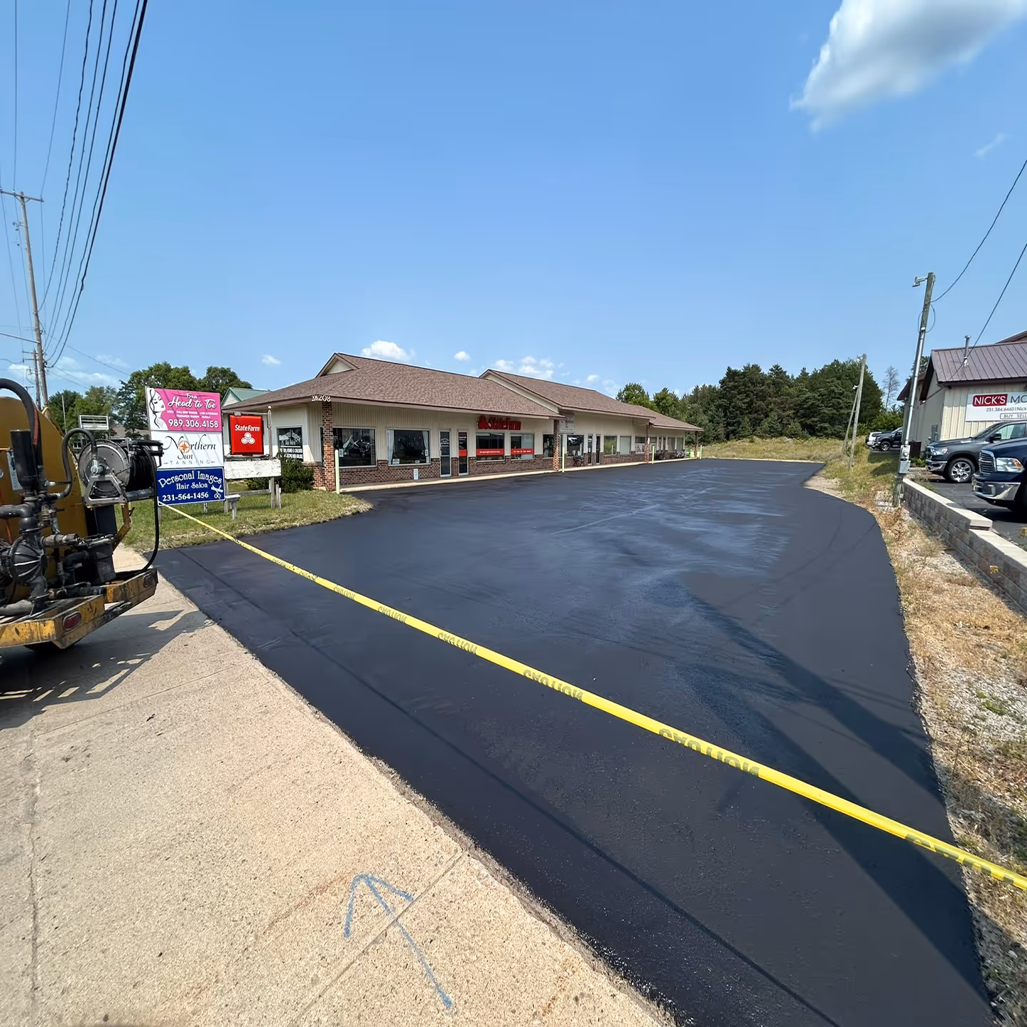 Professional commercial sealcoating for a multi-tenant business complex on N Cedar St (US-131) in Kalkaska, MI.